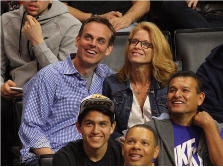 Colin Cowherd and Ann Cowherd enjoying their sporting event together while looking at the big screen in the stadium